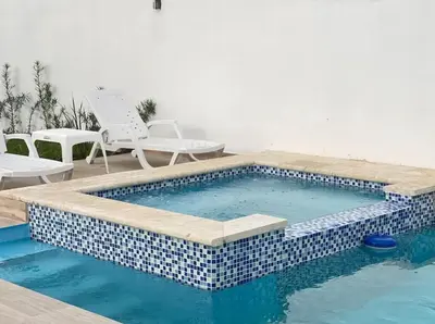 a swimming pool with a blue and white tiled pool at Villa Ferrer I in Jarabacoa