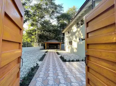 a house with a wooden door and a walkway at Villa Ferrer II in Jarabacoa