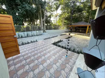 a backyard with a stone patio with a pond at Villa Ferrer II in Jarabacoa