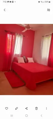 a red bed in a room with two windows at Apartamentos La Mina in Manuel Chiquito
