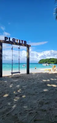 a sign on a beach with the ocean in the background at Apartamentos La Mina in Manuel Chiquito