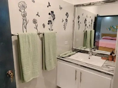 a bathroom with a sink and a mirror and towels at Nice rooftop apartment in La Cabirma