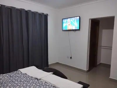 a bedroom with a bed and a tv on a wall at Alojamiento Residencial MAM in San Cristóbal
