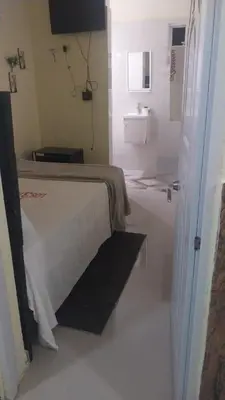 a white room with a bed and a sink at Hotel 3 Hnos in Comendador