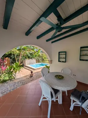 a patio with a table and chairs and a pool at Casa los Mangos Private pool 150 m from the beach in Las Galeras