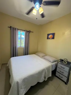 a bedroom with a bed and a ceiling fan at Cielo Alto in Jarabacoa