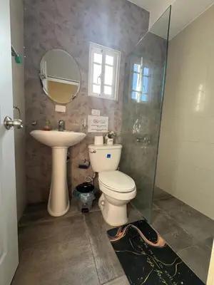 a bathroom with a toilet and a sink and a mirror at Cielo Alto in Jarabacoa