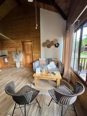 a living room with a couch and a table and chairs at Estaciones de Jarabacoa-Mountain Lodge in Jarabacoa
