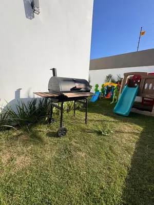 a grill sitting on a table in the grass at Luxury Caribbean Oasis, Private Pool & BBQ, 8 Guest in La Romana