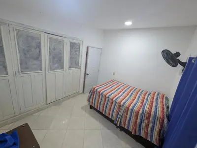 a bedroom with a bed and two windows at small apartment in a downtown area in Cruce de Veragua