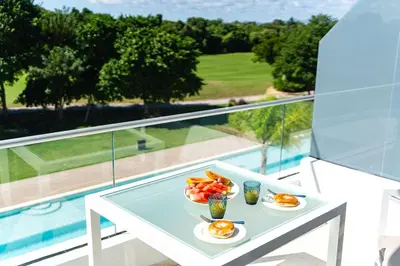 a table with plates of eggs and fruit on a balcony at Refugio Ideal Golf & Piscina Cana Rock Star in Punta Cana
