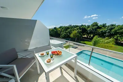 a table with a plate of food on a balcony at Refugio Ideal Golf & Piscina Cana Rock Star in Punta Cana
