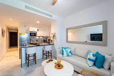 a living room with a couch and a kitchen at Refugio Ideal Golf & Piscina Cana Rock Star in Punta Cana