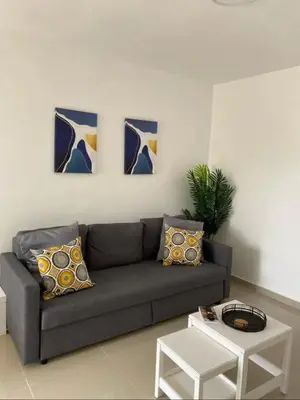 a living room with a couch and three paintings on the wall at Fully furnished 2 bedroom appart in Bayahibe