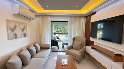a living room with a couch and a flat screen tv at 3BR Condo by the Airport Pool Gym Parking Security in Santiago de los Caballeros
