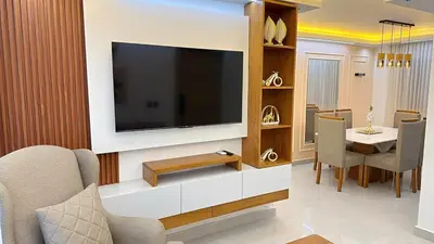 a living room with a television on a wall at 3BR Condo by the Airport Pool Gym Parking Security in Santiago de los Caballeros