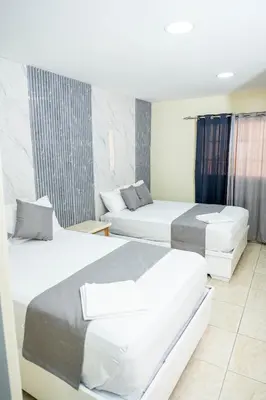 a hotel room with two beds in a room at Hotel Monterio in Azua