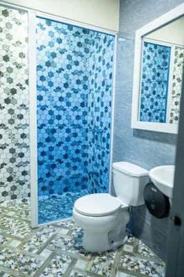 a bathroom with a toilet and a shower at Hotel Monterio in Azua