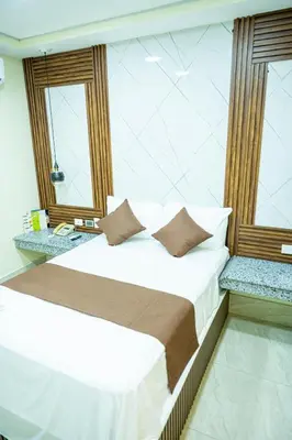 a bedroom with a bed and two windows at Hotel Monterio in Azua