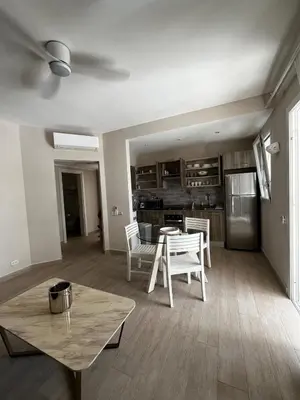 a living room with a table and a kitchen at Sunset Paradise Tracadero Apartment Sea pools access Private Garden WorkSpace in La Laguna