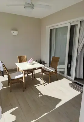 a dining room with a table and chairs on a balcony at Sunset Paradise Tracadero Apartment Sea pools access Private Garden WorkSpace in La Laguna
