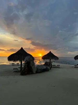 a beach with umbrellas and chairs and the ocean at Sunset Paradise Tracadero Apartment Sea pools access Private Garden WorkSpace in La Laguna