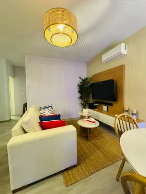 a living room with a white couch and a tv at 1BR Tracadero Lodge, beach access & full amenities in La Laguna