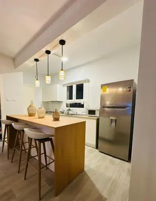 a kitchen with a table and a stainless steel refrigerator at 1BR Tracadero Lodge, beach access & full amenities in La Laguna