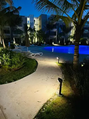 a pathway with palm trees and a pool at night at 1BR Tracadero Lodge, beach access & full amenities in La Laguna