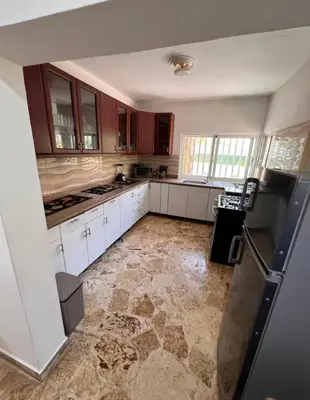 a kitchen with white cabinets and a tile floor at Villa Us Open in Sosúa