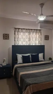 a bedroom with a large bed with a blue headboard at Residencial Altos de Alameda in Peralejo