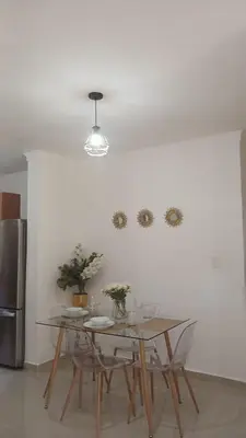 a dining room table with chairs and a refrigerator at Residencial Altos de Alameda in Peralejo
