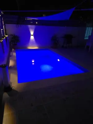 a swimming pool lit up at night with blue lights at Villa Yvelisse Pop Un paraíso próximo al Mar in San Felipe de Puerto Plata