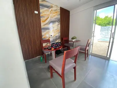 a dining room with chairs and a table and a window at Hostal y Piscina in La Romana