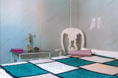 a bedroom with a bed with a white chair and a table at Modesto Apartamento para dos personas cerca del centro de Puerto Plata in San Felipe de Puerto Plata