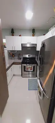 a kitchen with a stainless steel refrigerator and white cabinets at Cozy & Charming in Santo Domingo