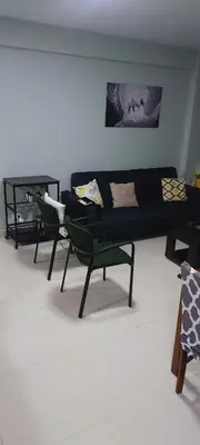 a living room with a black couch and two chairs at Cozy & Charming in Santo Domingo