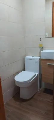 a bathroom with a white toilet and a sink at Cozy & Charming in Santo Domingo