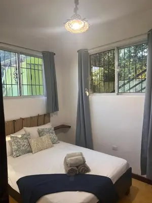 a bedroom with a large bed with two windows at La Española JW in Las Galeras