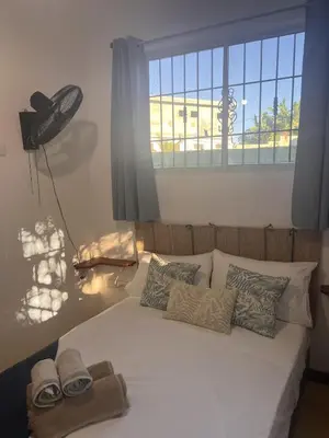 a bedroom with a bed with towels and a window at La Española JW in Las Galeras