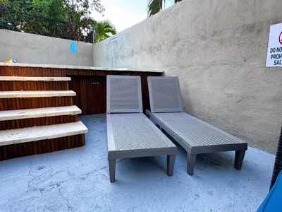 two chairs and a bench next to a wall at Haven Villa Retreat Jacuzzi Oasis for 16 in Mata los Indios