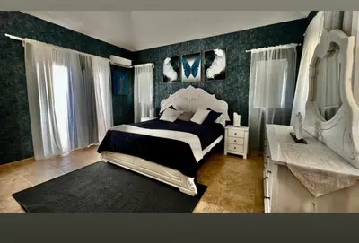 a bedroom with a black and white bed and a desk at Villa Robilu