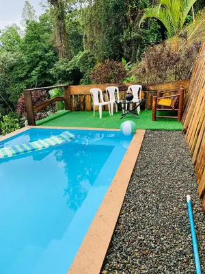 a swimming pool in a backyard with a table and chairs at Villa el privilegio in Jarabacoa
