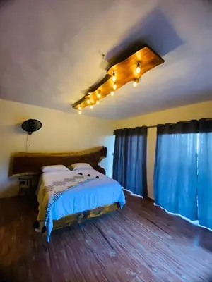 a bedroom with a bed with blue curtains and a ceiling at Villa el privilegio in Jarabacoa