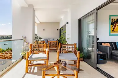 a group of chairs sitting on a balcony at Modern Oceanview Retreat with Balcony and Walk to Bay in Santa Bárbara de Samaná