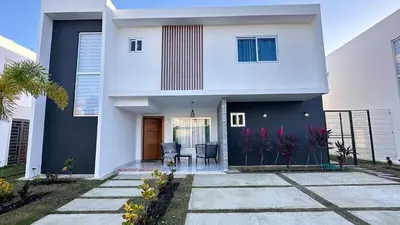 a white house with a black door at VILLA 127 La Intensa Del Caribe in Pueblo Bavaro