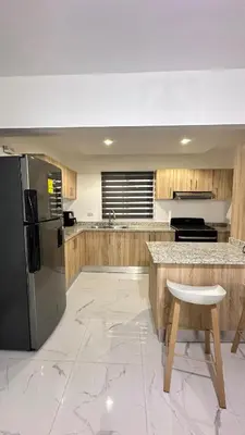 a kitchen with a stainless steel refrigerator and wooden cabinets at VILLA 127 La Intensa Del Caribe in Pueblo Bavaro