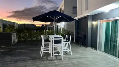 a table and chairs with an umbrella on a balcony at VILLA 127 La Intensa Del Caribe in Pueblo Bavaro
