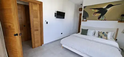 a bedroom with a bed with a bird painting on the wall at SunSeaBeach Villa Iguana - 3 SZ - Strandnähe in Las Galeras