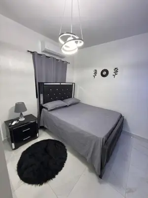 a bedroom with a bed and a black rug at EG suits rentals in San Felipe de Puerto Plata